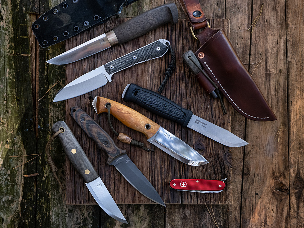 Left to right fixed blade: Pawel Michalski custom puukko, Chris Reeve Nyala, Mora Garberg, Helle Utvaer, Harsey custom Nessmuk, Sargent 'SET' M3C, Victorinox Farmer for size reference