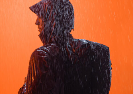 man in rain with black backpack on
